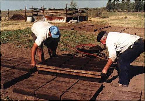 Desmoldando adobes en el pisadero.