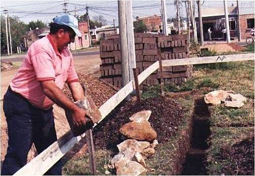 Albañil Ganicoche colocando piedra de cimiento.