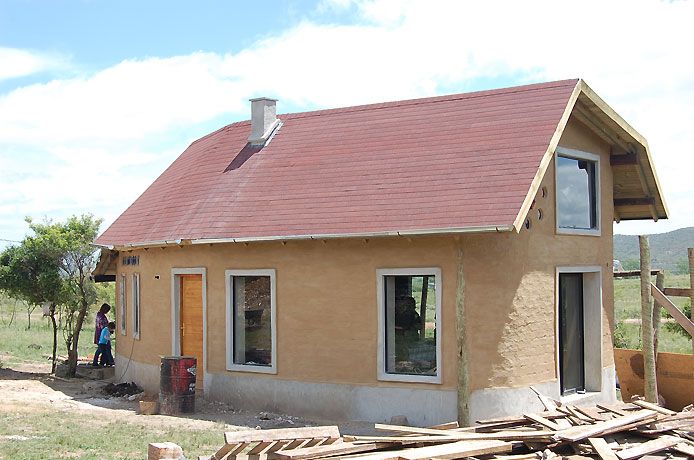 Fachada casi terminada: techo de teja americana, aislación barro-paja y cielorraso de madera.