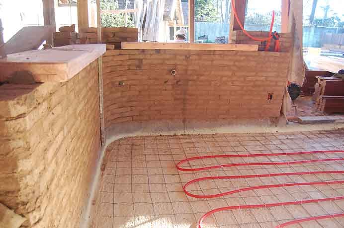 Losa radiante de agua caliente (sistema de colector solar, calefactor a leña y gas hacia un acumulador de agua caliente).