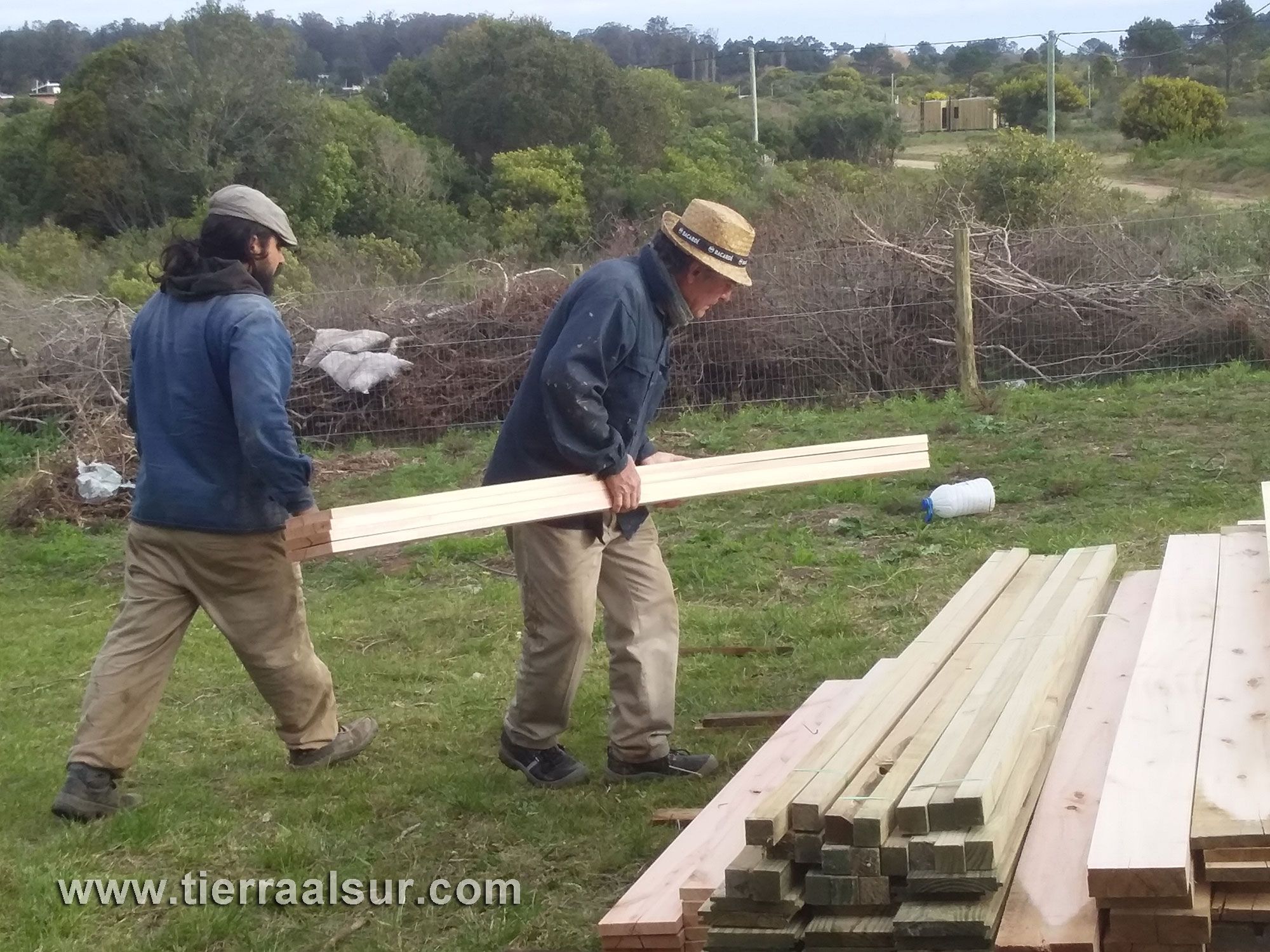Nicolas Ruetalo (constructor encargado de obra y Vicente Ruetalo), bajando maderas para la estructura (de Aserradero Rocha).